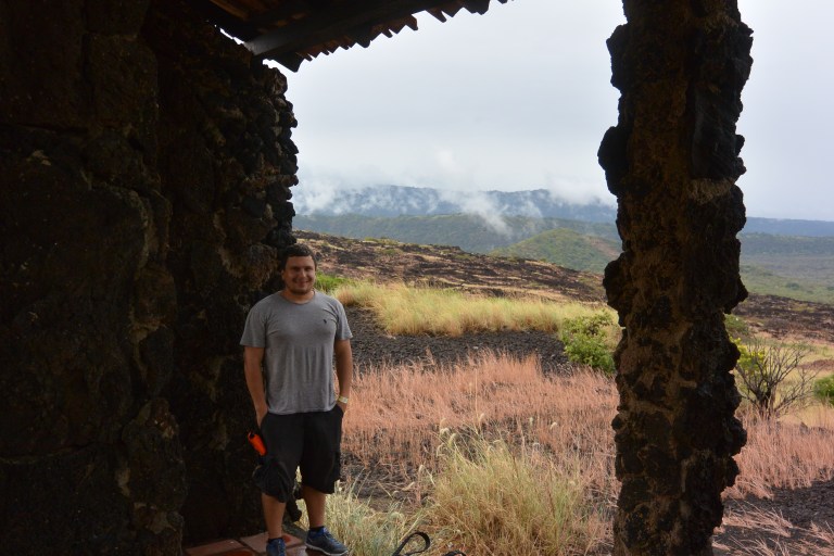 Fog rolling over the volcanic slope as we watch from our not-so-protective rain shelter